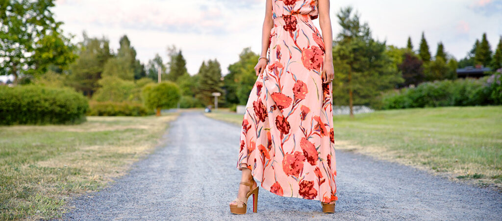 modelka w kwiecistej sukience maxi i brązowych sandałach na obcasie