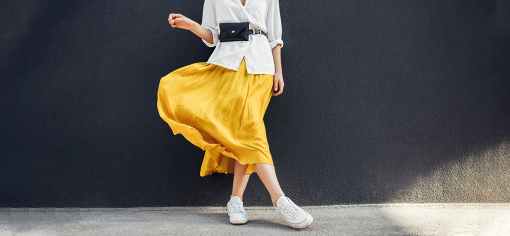 Kobieta w żółtej spódnicy i białych butach