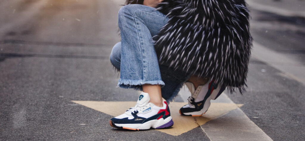 Kolorowe sneakersy z jeansami i płaszczem
