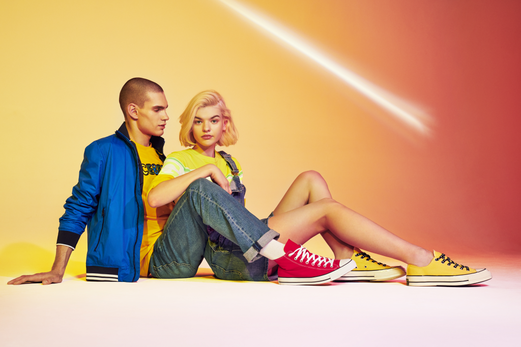 Para młodych ludzi w streetwearowych stylizacjach z trampkami Converse