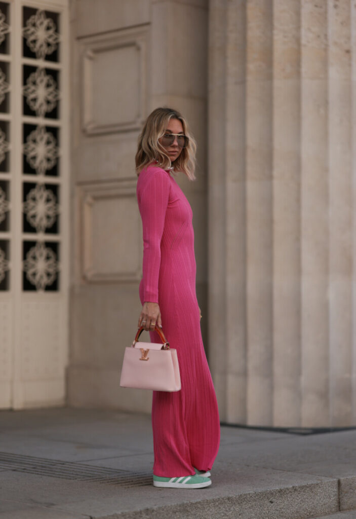 kobieta ubrana w różowa sukienkę i buty adidas gazelle w pastelowym odcieniu