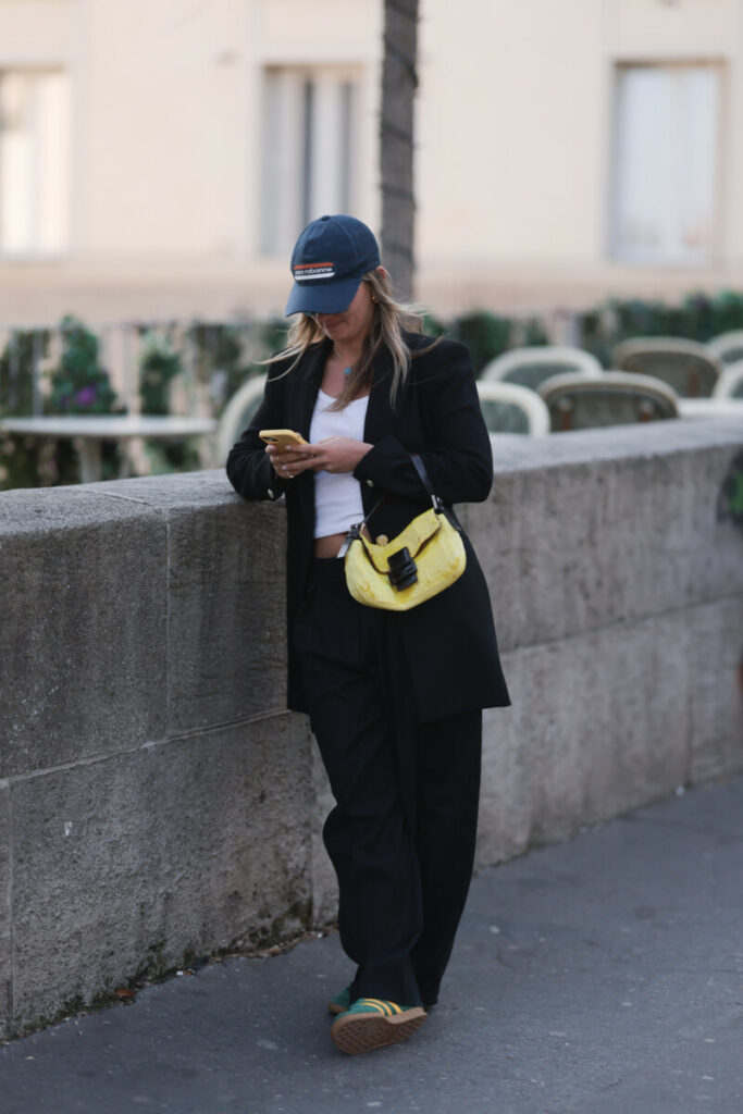 kobieta w czarnym garniturze damskim i sneakersach adidas