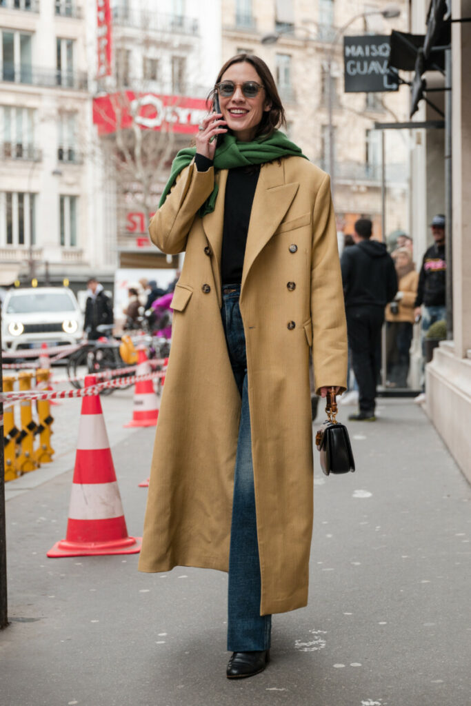 Alexa Chung w stylizacji z beżowym płaszczem i zielonym szalikiem